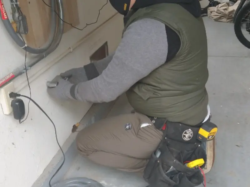 Electrician performing outlet wiring in a Dubuque garage
